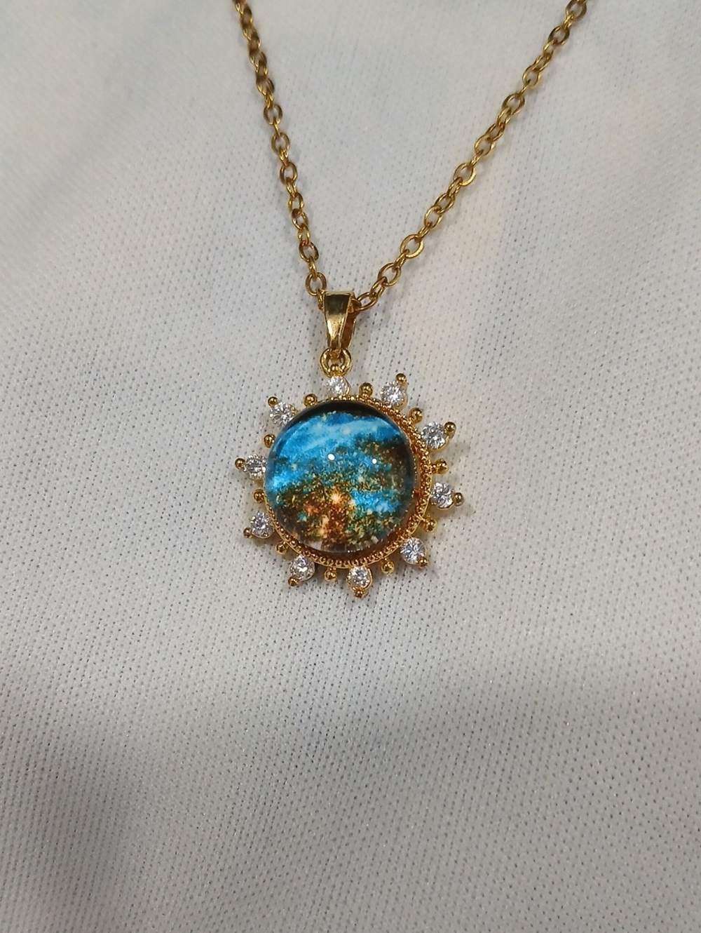 Gold Sunburst Pendant Necklace with Blue-Green Resin Center